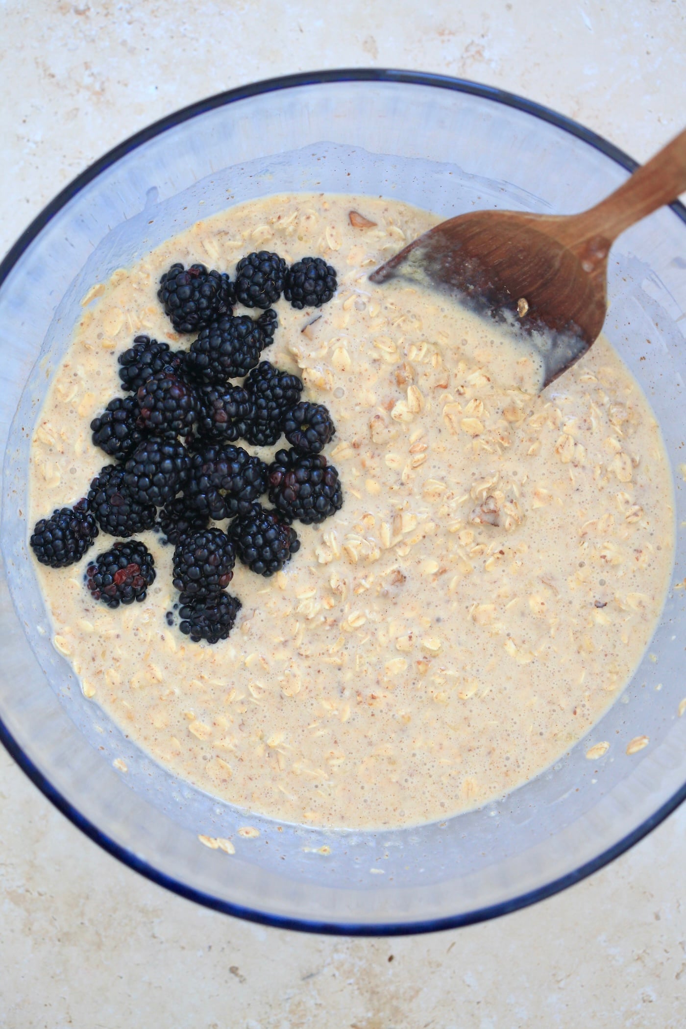 mixed oatmeal with blackberries in mixing bowl.