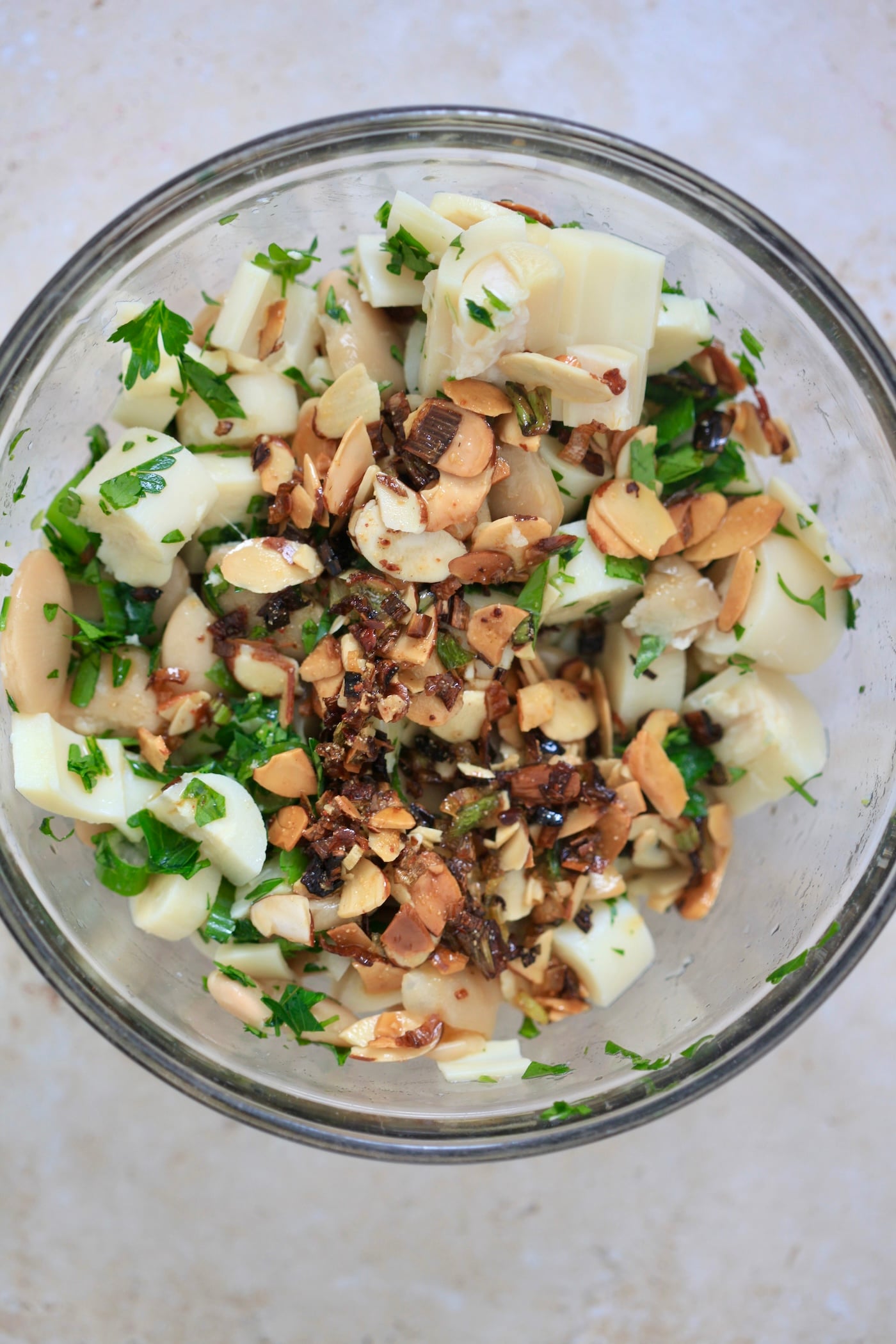 beans in bowl with almond mixture on top.