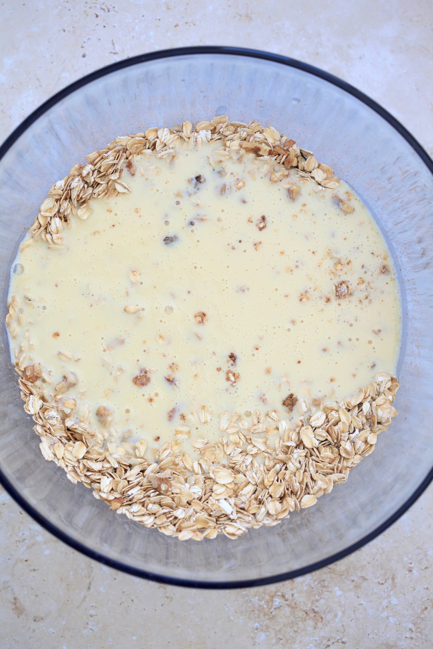 yellow liquid over oats in blue bowl.