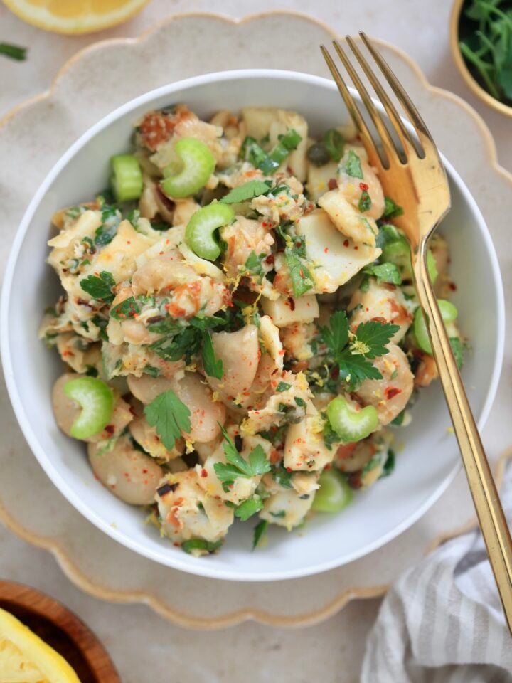 bowl with bean herby bean salad, lemon and gold fork
