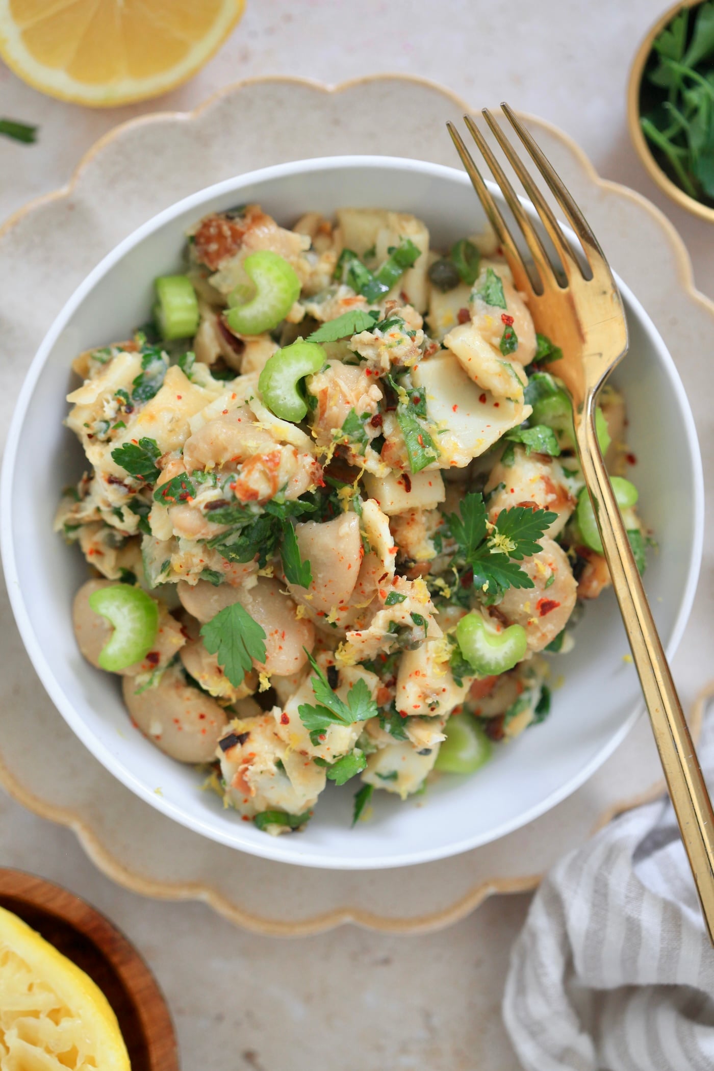 bowl with bean herby bean salad, lemon and gold fork