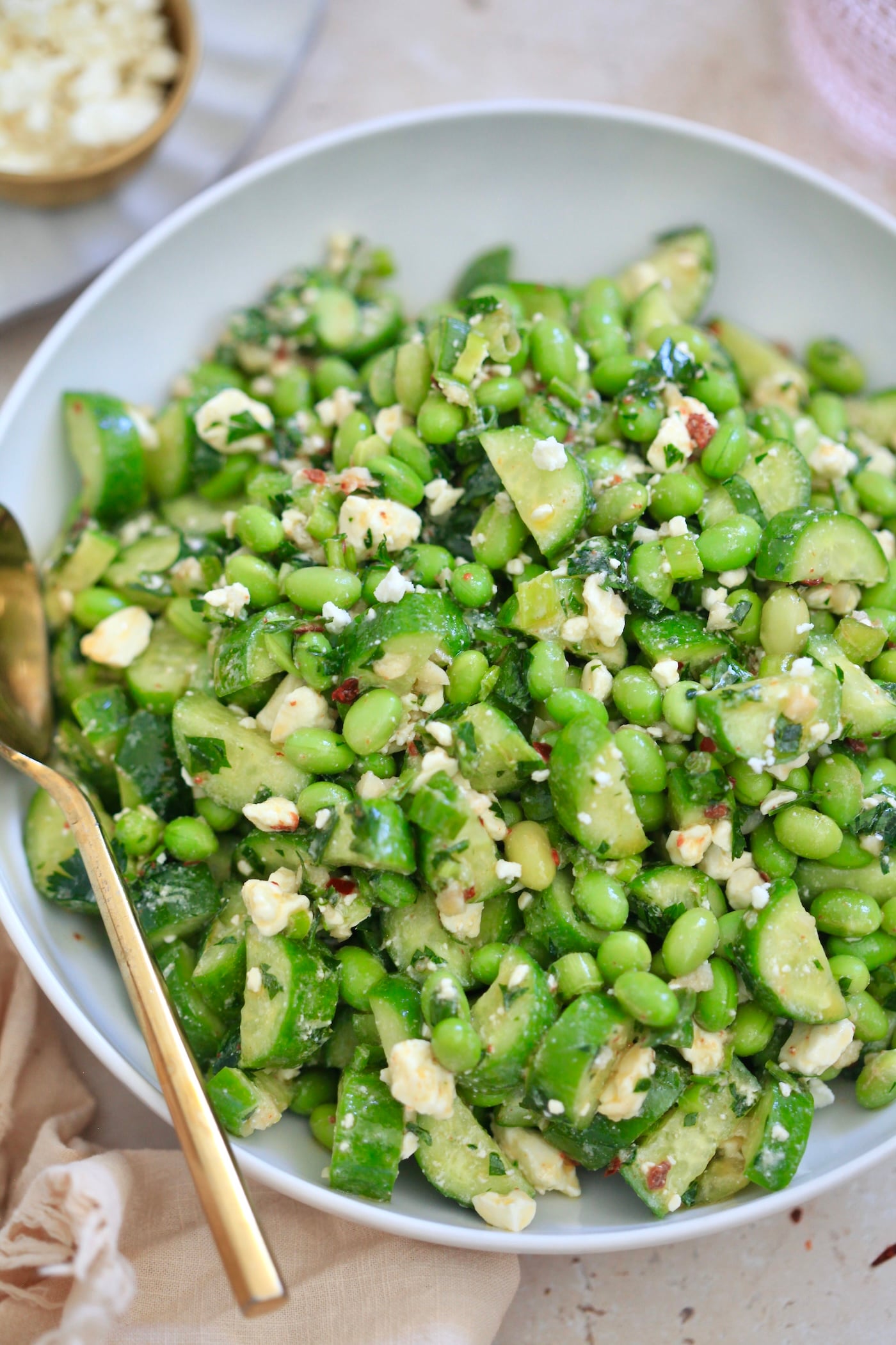 up close view of edamame salad in white bowl.