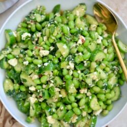 bowl with green edamame salad and gold spoon.