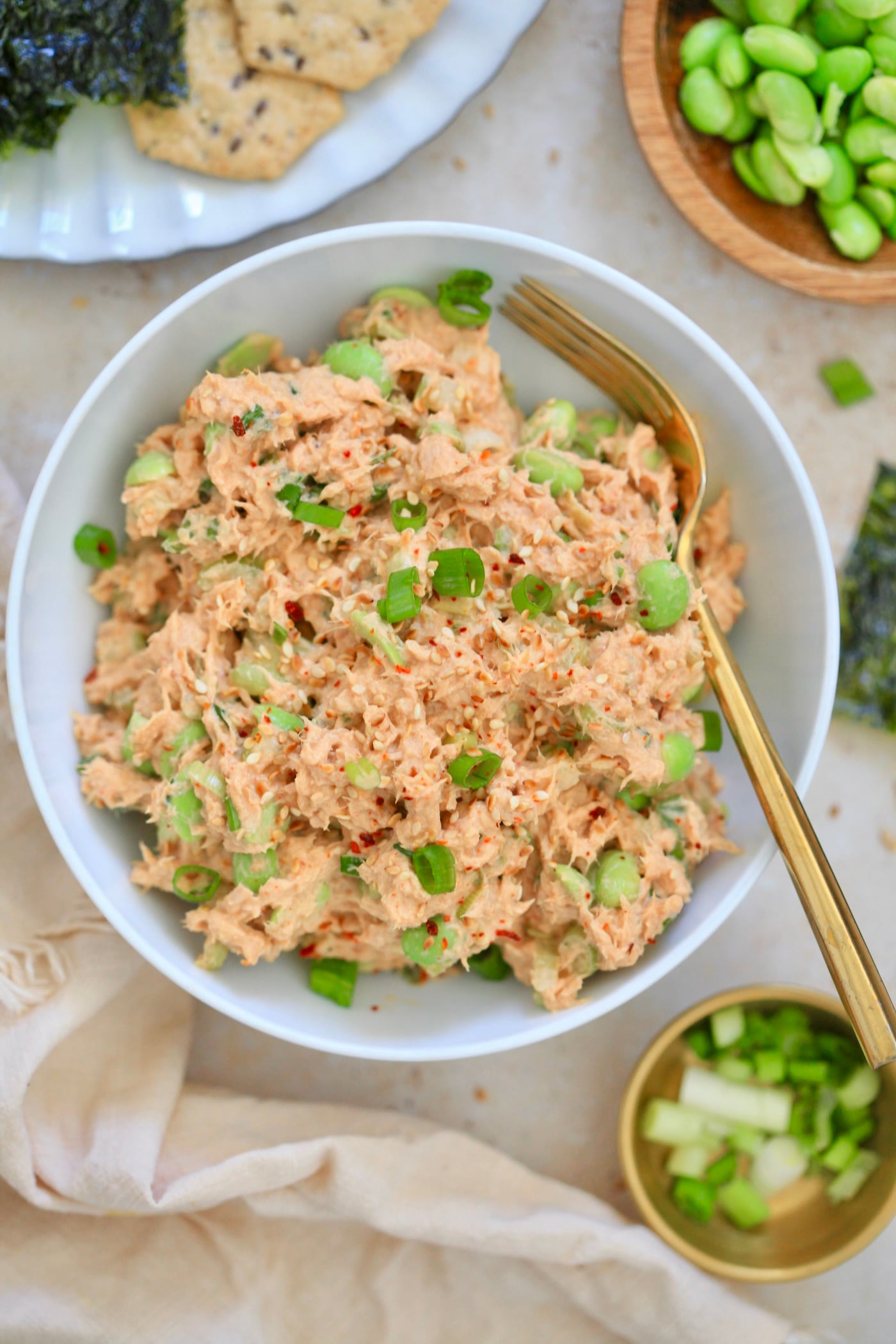 orange tuna in white bowl with green veggies.