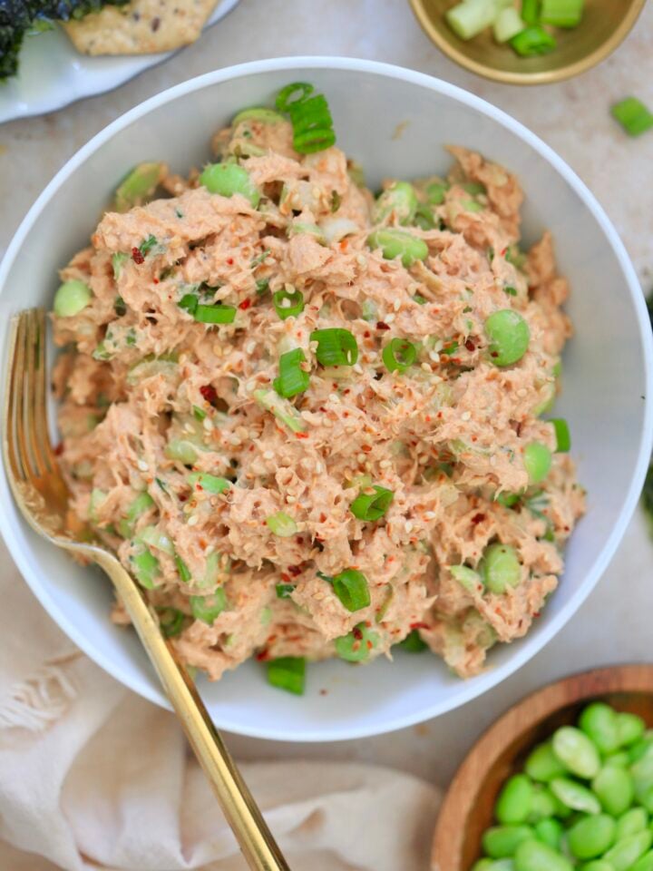 bowl with pink creamy tuna salad with green bits.