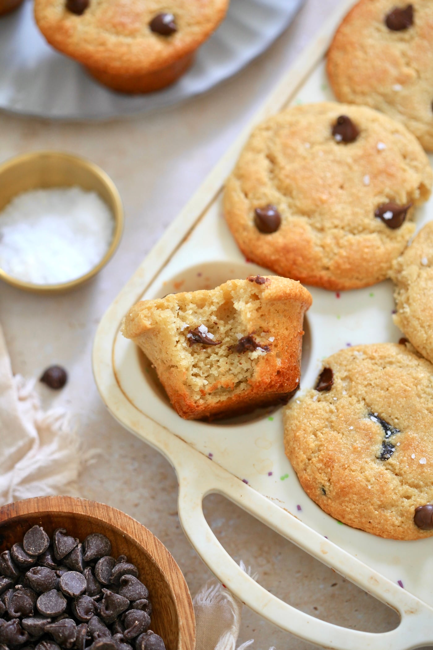 chocolate chip muffin with bite taken out of it in tin.