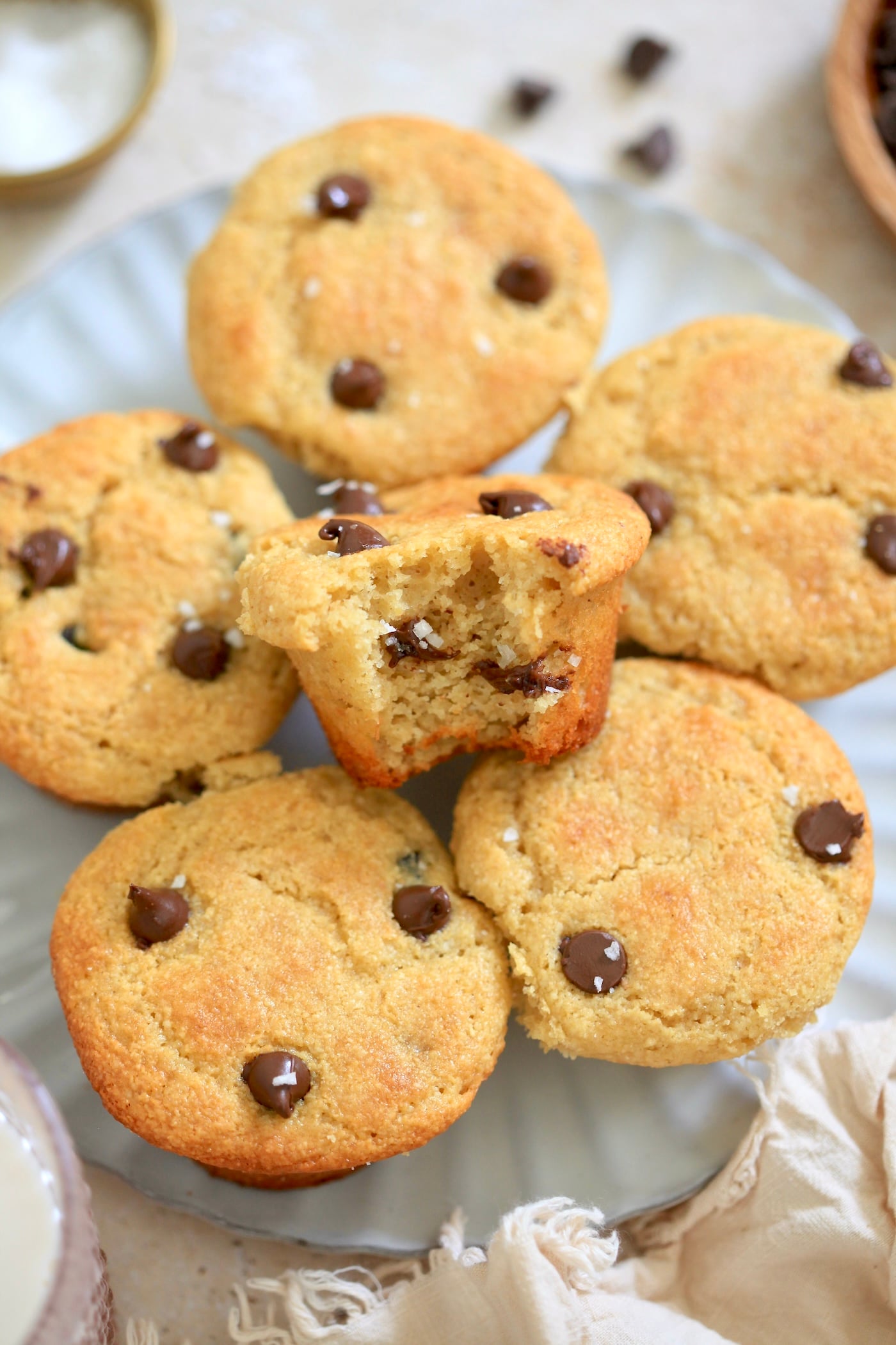 plate of chocolate chip muffins with bite taken out.