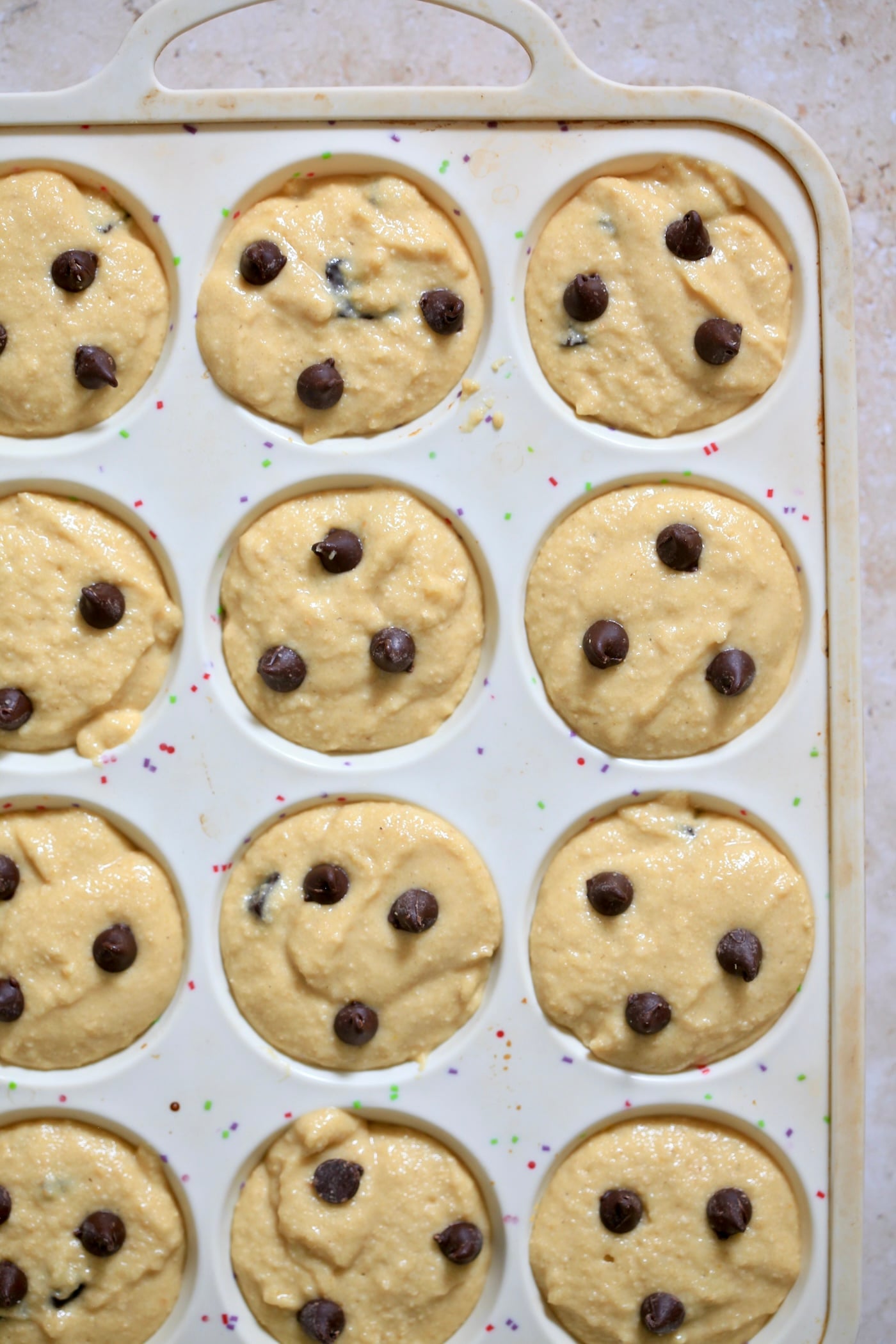 unbaked chocolate chip muffins in tin.