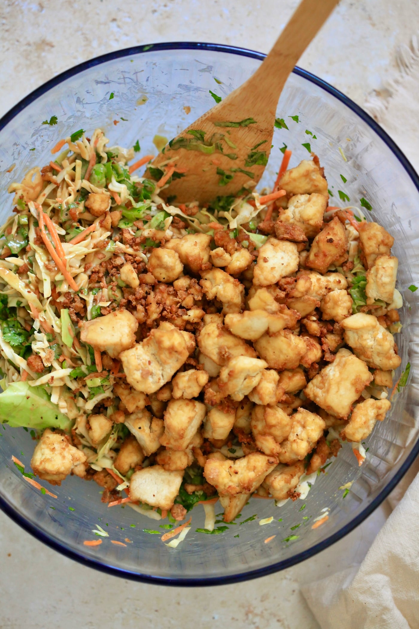 colorful veggie salad in bowl with cooked tofu on top.