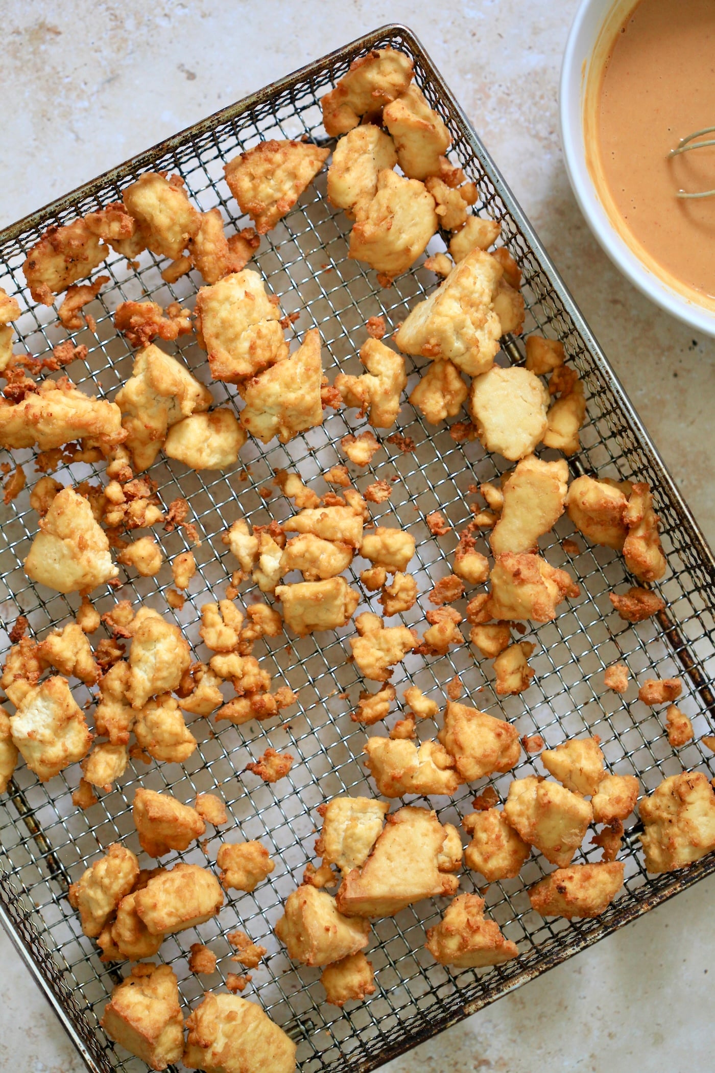 cooked tofu in air fryer basket.