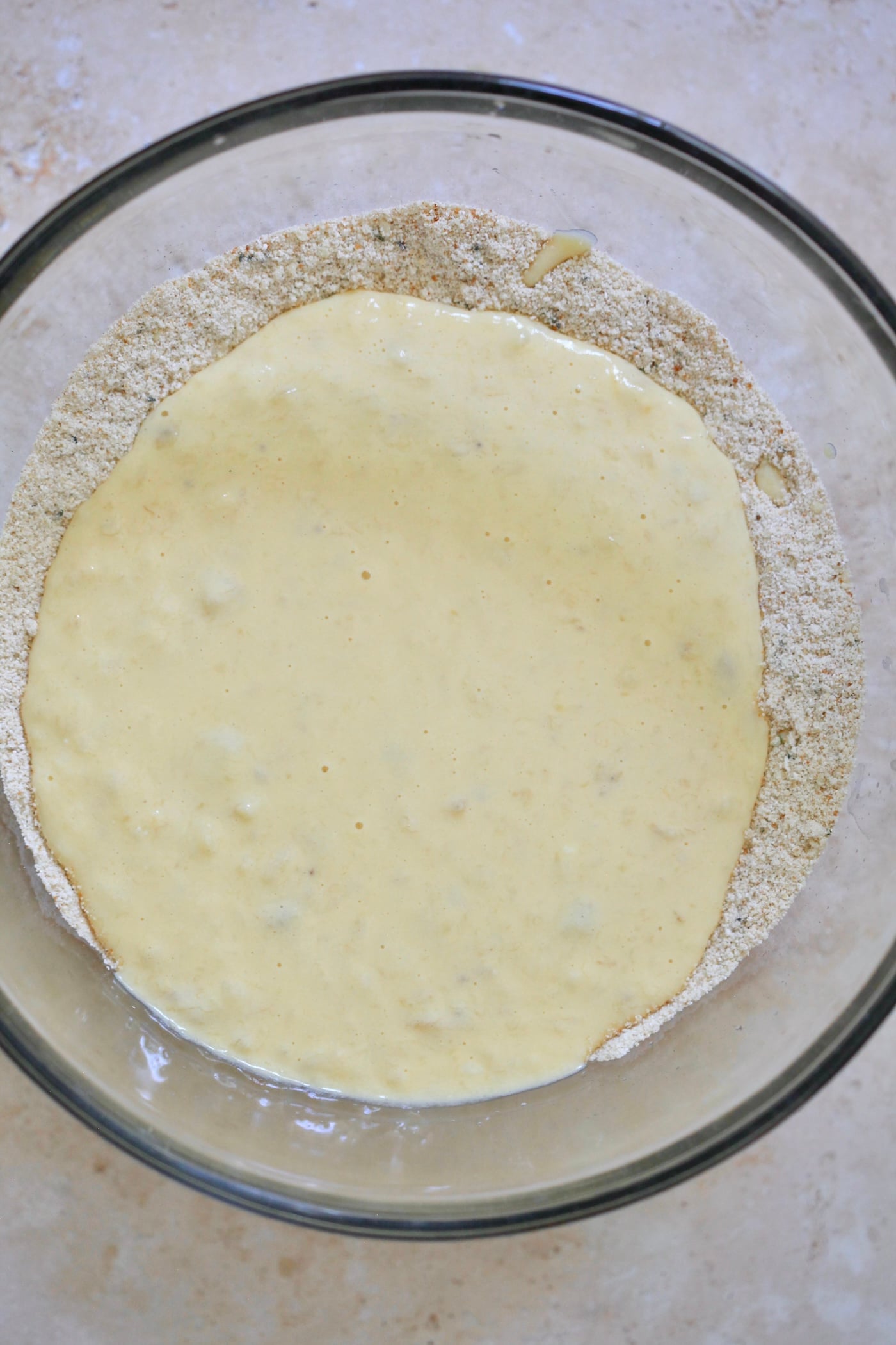 blended wet ingredients on top of flour in bowl
