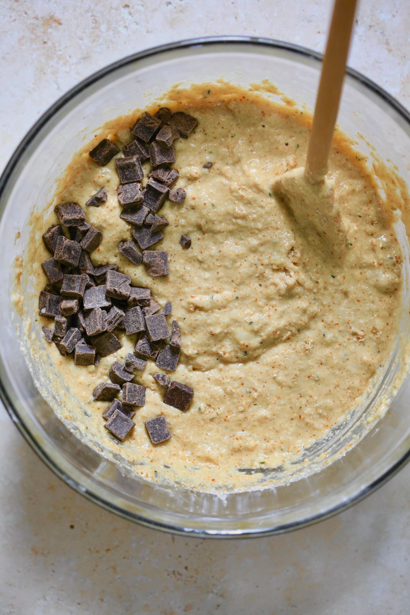 mixed batter with chocolate chunks and wooden spoon.