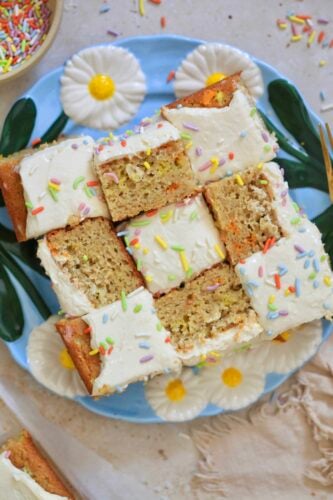 frosted cake pieces on blue plate with rainbow sprinkles.
