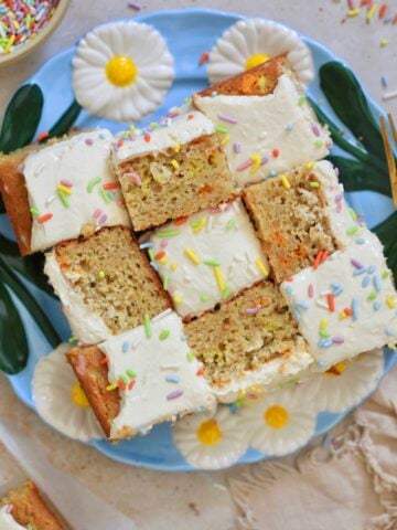 frosted cake pieces on blue plate with rainbow sprinkles.