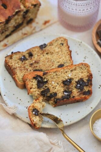 two slices chocolate chunk banana bread on plate with bite taken out.