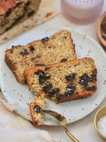 two slices chocolate chunk banana bread on plate with bite taken out.